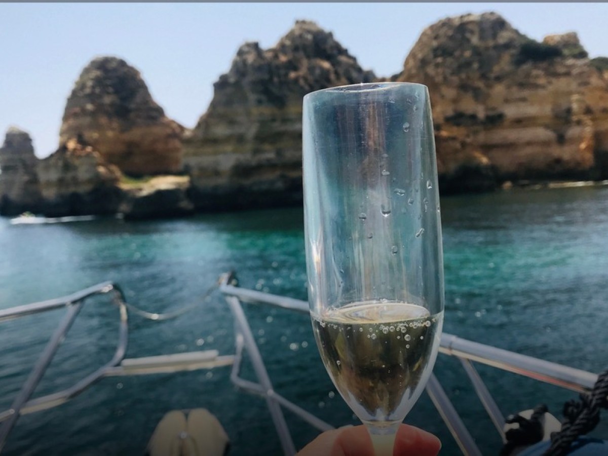 a glass of wine next to a body of water