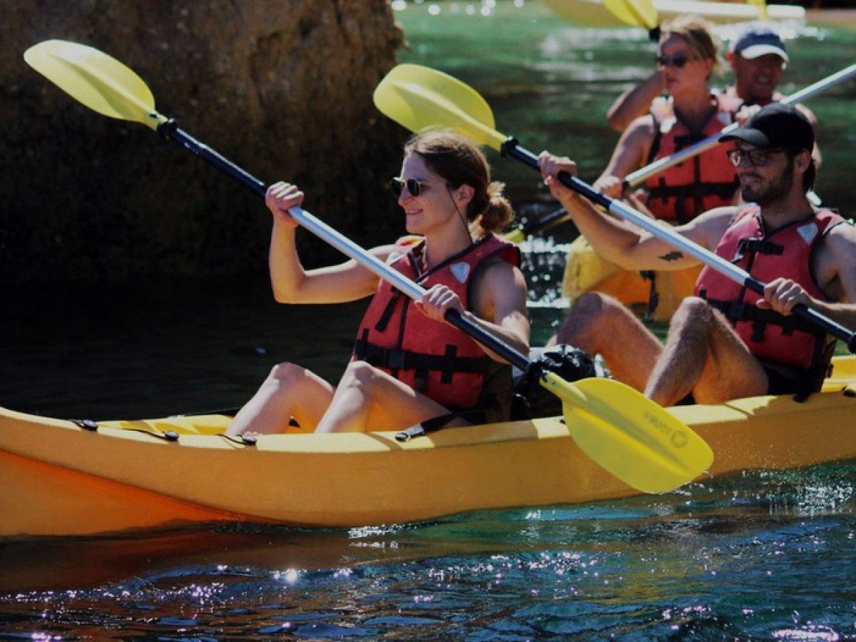 a group of people riding on the back of a boat in the water